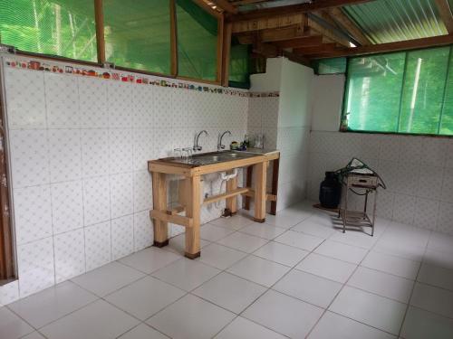 uma casa de banho com lavatório e piso em azulejo em Cabañas del bosque Don Efraín-La Merced em La Merced