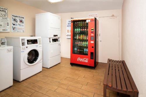 a cocacola refrigerator and a washing machine in a room at Red Roof PLUS Miami Airport in Miami