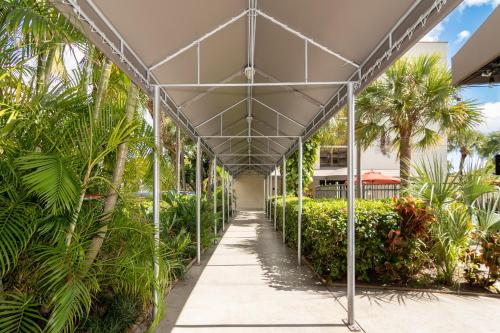 a covered walkway in a building with palm trees at Red Roof PLUS Miami Airport in Miami