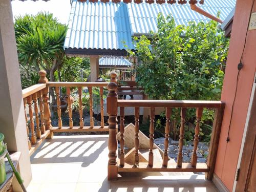 a wooden railing on a porch with plants at Hello Sichang Bungalow in Ko Si Chang
