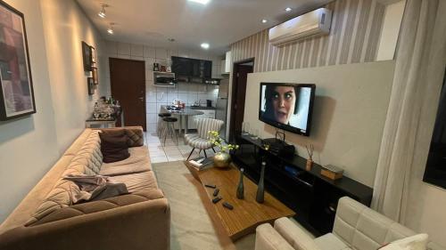 uma sala de estar com um sofá e uma televisão na parede em Flat 203 Clarice Lispector, Ilhotas- Teresina em Teresina