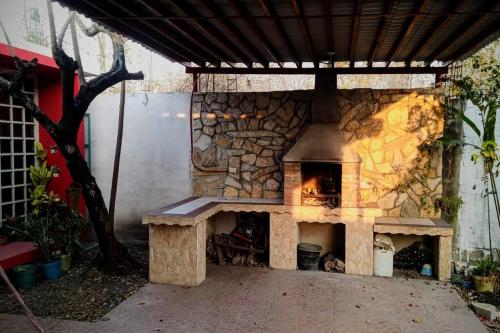 - une cheminée en pierre dans une terrasse avec une cheminée dans l'établissement Casa de campo en Ciudad Valles, à Ciudad Valles