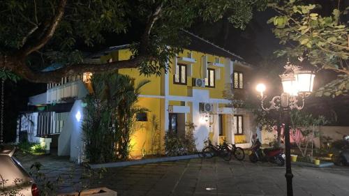 un bâtiment jaune et blanc avec des vélos garés devant lui dans l'établissement Mother's Inn Homestay, à Cochin