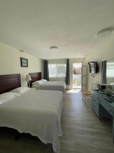 a hotel room with two beds and a television at Empire Motel in Penticton