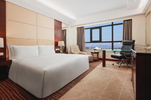 順義的住宿－北京臨空皇冠假日酒店，酒店客房设有一张白色大床和一张书桌