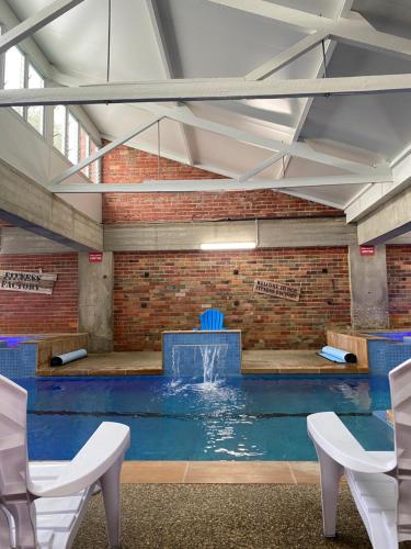 a swimming pool with a fountain in a brick wall at Sovereign Park Motor Inn in Ballarat