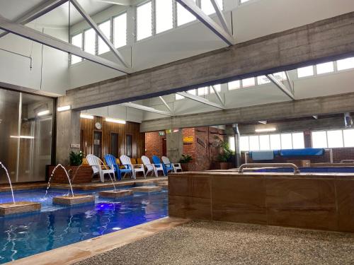 a pool in a building with chairs and a swimming pool at Sovereign Park Motor Inn in Ballarat