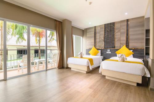 a bedroom with two beds and a balcony at Andakira Hotel - SHA Extra Plus in Patong Beach