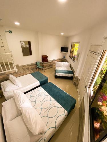 a room with two beds and a couch in it at Hotel Campestre Villa Mary in Santa Rosa de Cabal