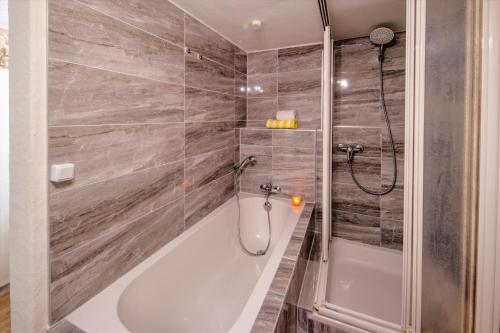 a bathroom with a bath tub and a shower at City Ferienhaus Vulkaneifel in Daun