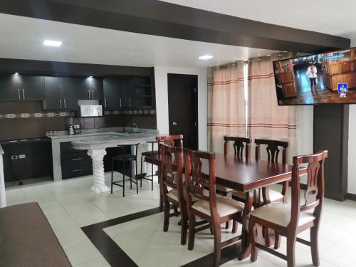 a kitchen and dining room with a table and chairs at GIGAHOUSE in Baños