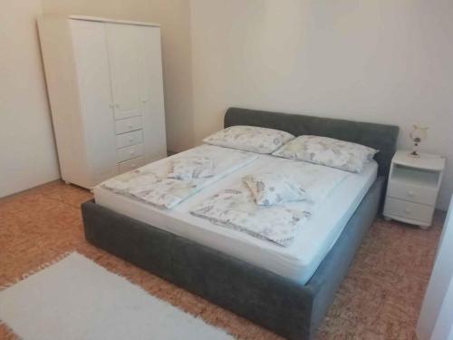 une chambre avec un grand lit avec une table de chevet dans l'établissement Holiday home in Balatonkeresztur 44078, à Balatonkeresztúr