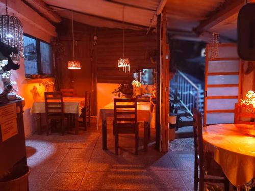 Temazcal Hospedaje "gema" adults only في تيبوزتلان: غرفة طعام مع طاولات وكراسي وأضواء