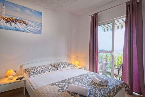 um quarto com uma cama e uma grande janela em Apartments in Mlini 44021 em Mlini