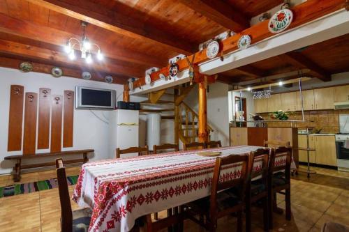 a dining room with a table and a kitchen at Casa Cornel in Vartop