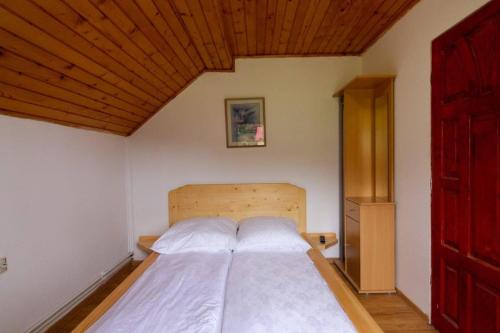 a bedroom with a large bed with a wooden ceiling at Casa Cornel in Vartop