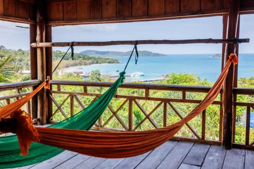 a hammock on a porch with a view of the ocean at Sweet View Guesthouse in Koh Rong