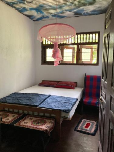 ein kleines Schlafzimmer mit einem Bett und einem Kronleuchter in der Unterkunft Hostel Singha Lounge in Unawatuna