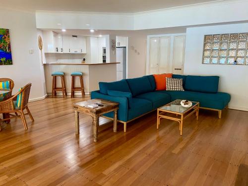a living room with a blue couch and a table at BeachView Apartments at Villa Paradiso in Palm Cove