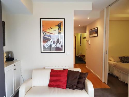 a living room with a white couch with a red pillow at Alto 203 in Mount Buller