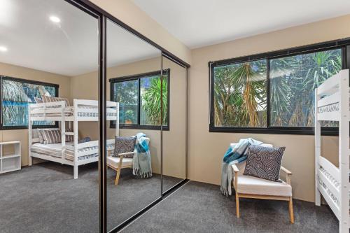 Zimmer mit Etagenbetten und einem Spiegel in der Unterkunft Orton Oceanview Luxury Retreat in Ocean Grove