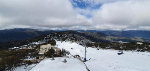 a snow covered mountain with a ski resort on it at Beehive 18 in Mount Buller