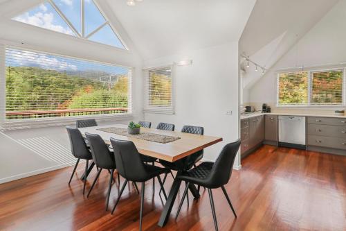 a kitchen and dining room with a table and chairs at Jarrah Lodge in Merrijig