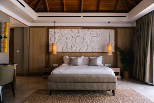 a bedroom with a bed and a large wall at Miskawaan Villa Wayu in Mae Nam