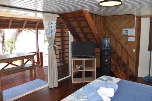 um quarto com uma cama e uma televisão num quarto em Fare Aute Beach em Vaianae