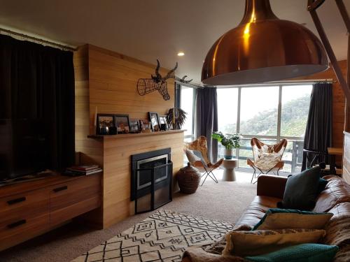 uma sala de estar com um sofá e uma lareira em SKI View 1 em Mount Buller