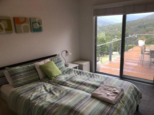 Schlafzimmer mit einem Bett und Blick auf eine Terrasse in der Unterkunft Stirling View in Merrijig
