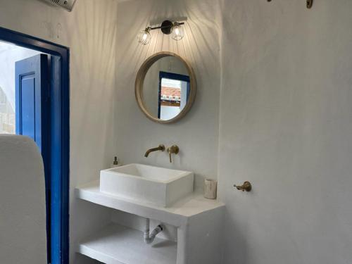 ein Badezimmer mit einem weißen Waschbecken und einem Spiegel in der Unterkunft Lemon House in Hydra