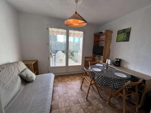 un salon avec une table et un canapé dans l'établissement Studio Économique avec Piscine, Terrasse et Parking à Valras-Plage, à 500m de la Plage - FR-1-701-56, à Valras-Plage