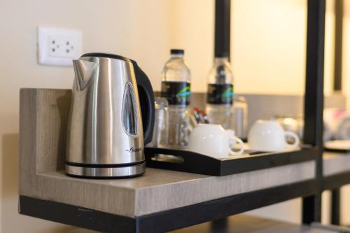 a coffee maker on a counter with cups and bottles at Andakira Hotel - SHA Extra Plus in Patong Beach