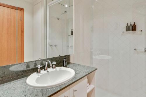 a white bathroom with a sink and a shower at Mawson 5 in Mount Buller