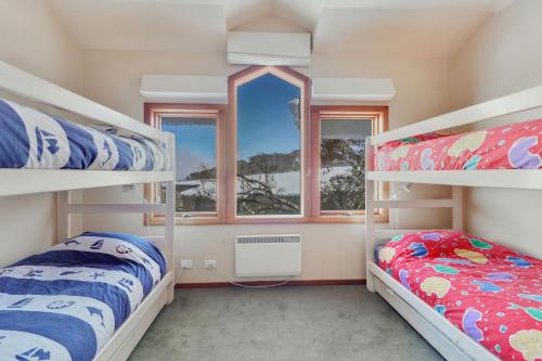 a bedroom with two bunk beds and a window at Mawson 5 in Mount Buller