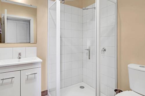 a white bathroom with a shower and a sink at Elouera in Mansfield