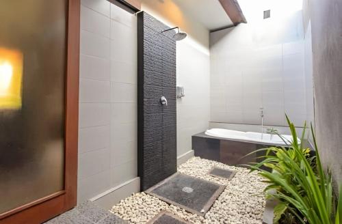 y baño con ducha, aseo y lavamanos. en RS Beautiful Villa Sanur, en Denpasar