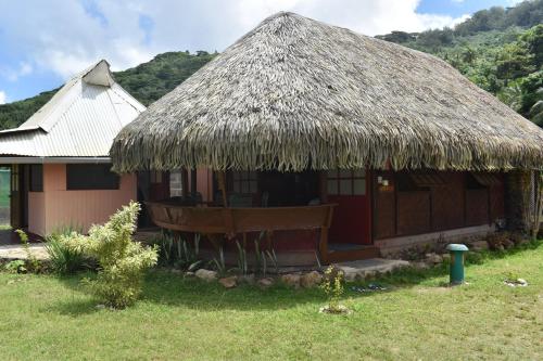 a small hut with a thatched roof in a field at Fare Aute Beach in Vaianae