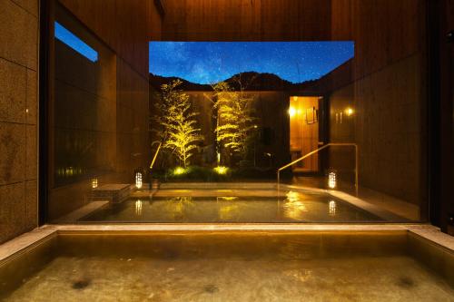 a jacuzzi tub in a building with a view at Sanso Amanosato in Katsuragi