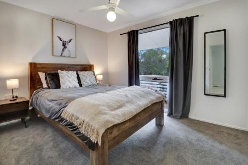 een slaapkamer met een groot bed en een raam bij Katta Cottage in Mansfield