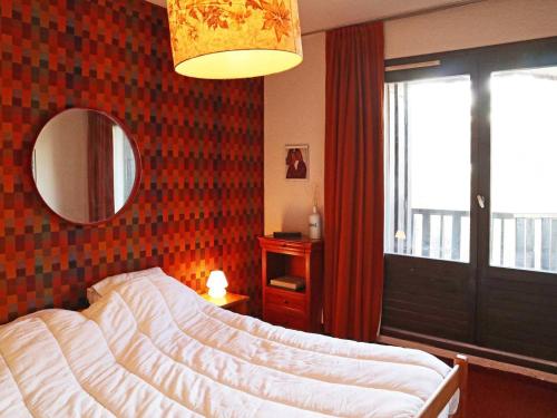 une chambre avec un lit, un miroir et une fenêtre dans l'établissement Appartement spacieux au centre des Orres 1650, 3 chambres, pour 6/8 personnes - FR-1-322-521, aux Orres