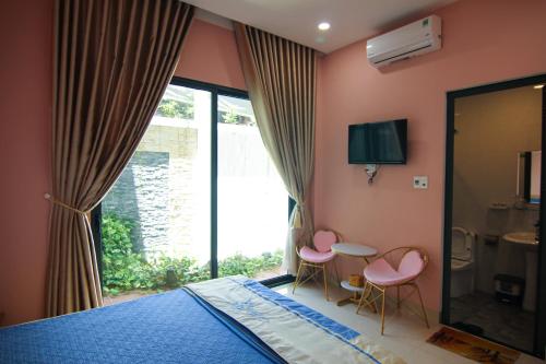 1 dormitorio con 1 cama, 2 sillas y ventana en Nemo Homestay, en Hue