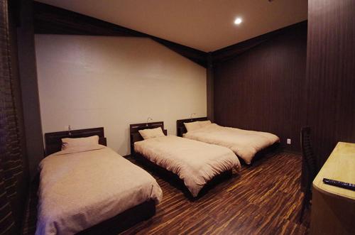 um quarto com duas camas num quarto em リゾートイン青の洞窟 em Ishigaki