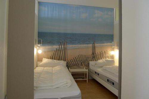 two beds in a room with a view of the beach at Panorama Whg 73, 5 OG in Cuxhaven