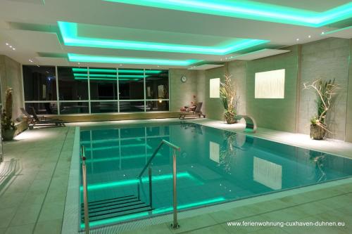 a swimming pool with blue lights in a building at Panorama Whg 62, 4 OG in Cuxhaven