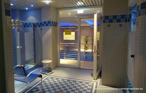 a bathroom with a shower with a chair and a table at Panorama Whg 62, 4 OG in Cuxhaven