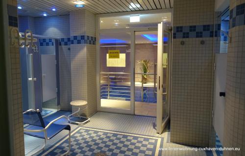 La salle de bains est pourvue d'une douche, d'une chaise et d'une table. dans l'établissement Panorama Whg 111, 8 OG, à Cuxhaven