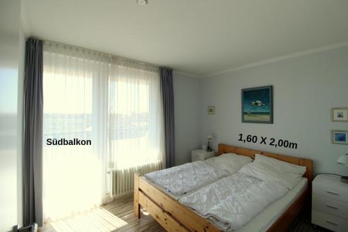 um quarto com uma cama e uma grande janela em Panorama Whg 57, 4 OG em Cuxhaven
