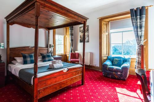 a bedroom with a canopy bed and a chair at Columba House in Kingussie
